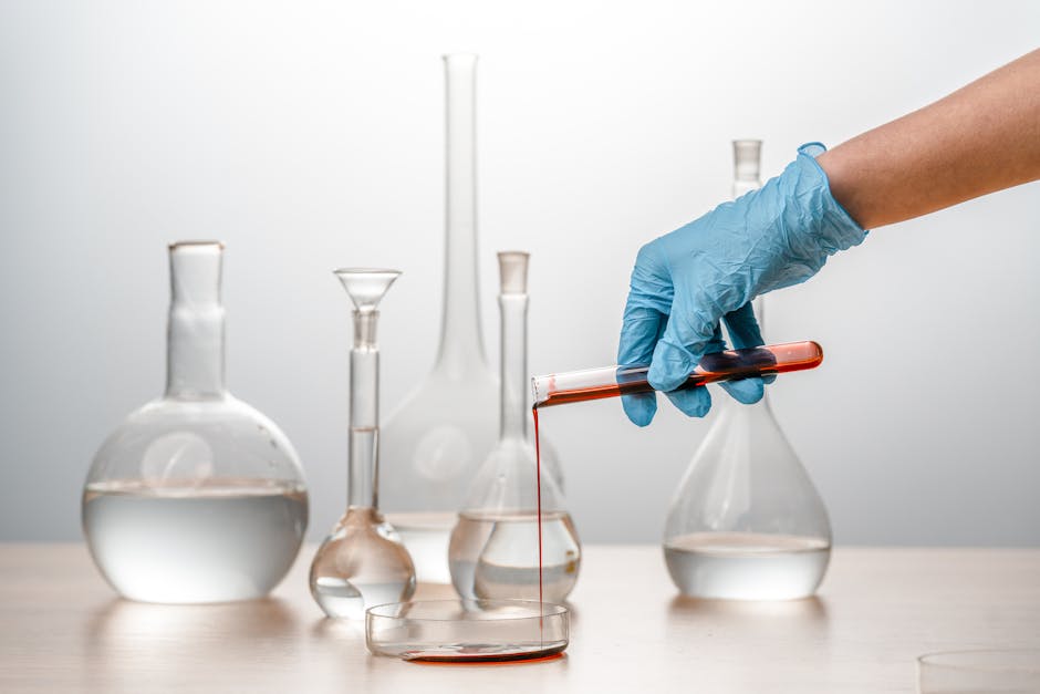 Close-up of a scientist pouring liquid into a petri dish in a lab.